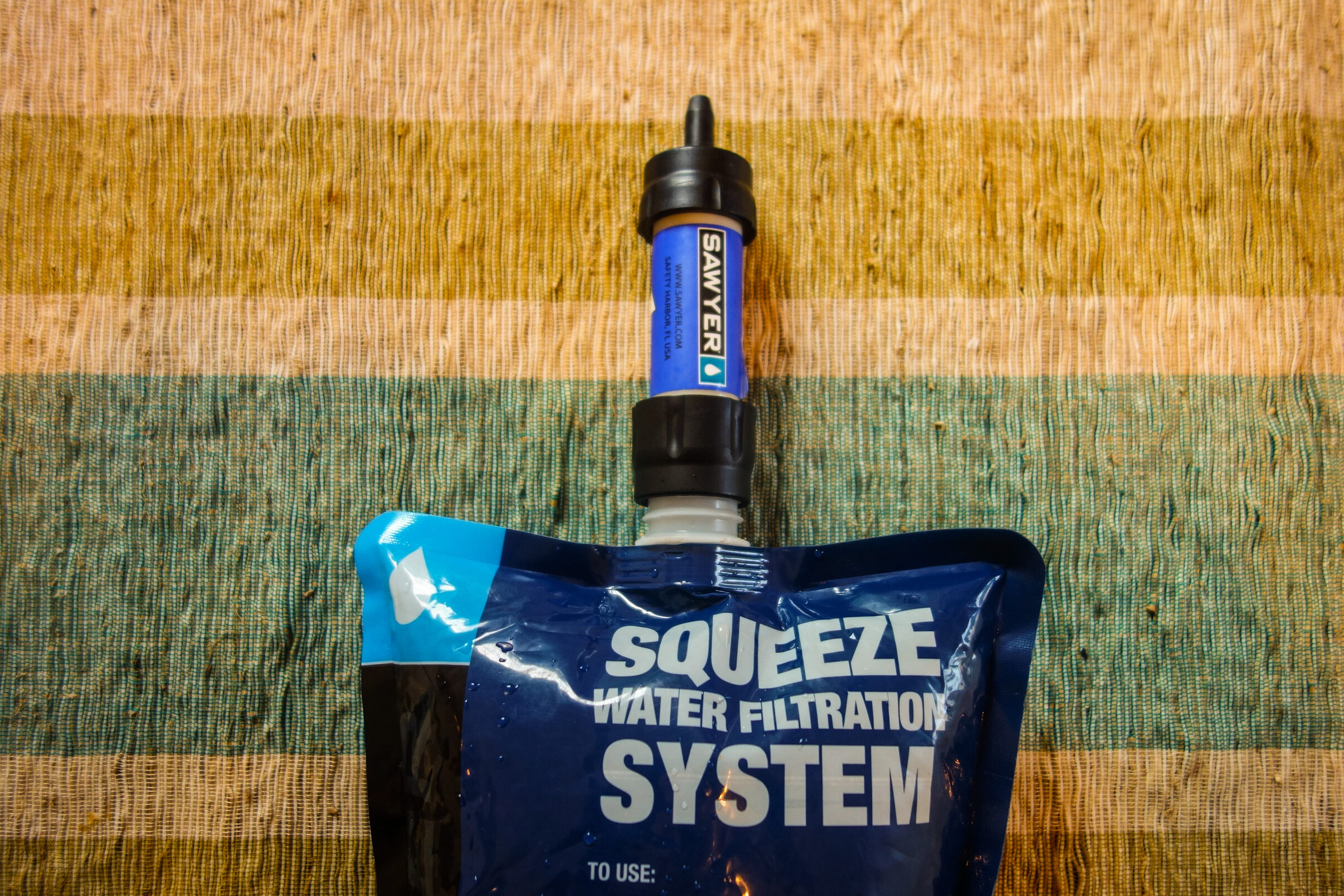 sawyer mini attached to a squeeze filter pouch for treating water to drink in the wilderness