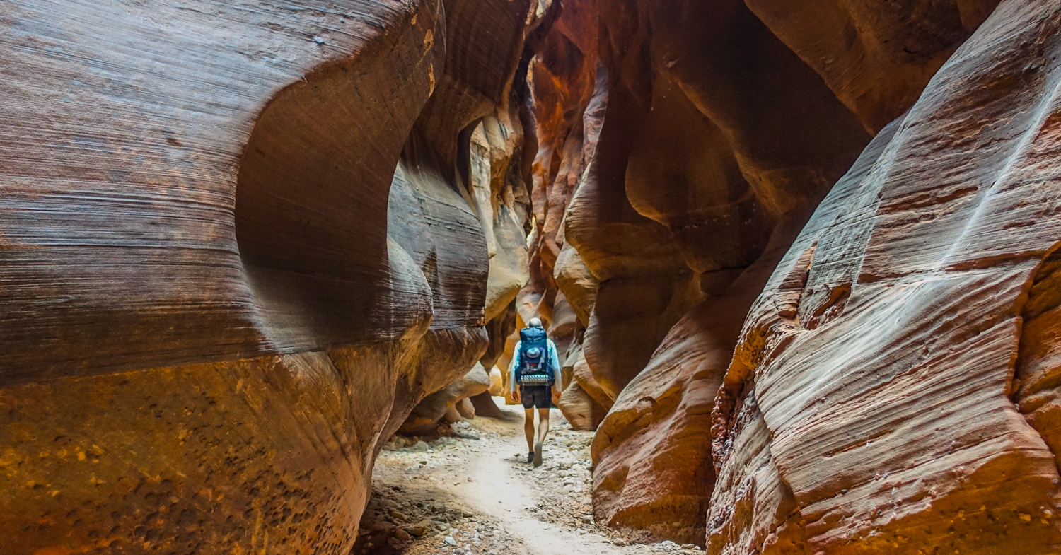 a backpacker walks through paria canyon