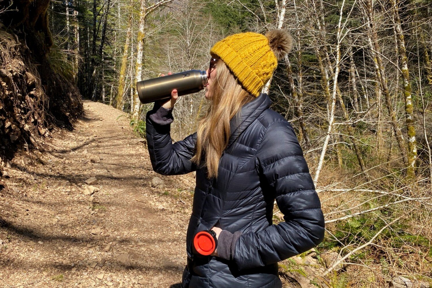 https://www.cleverhiker.com/wp-content/uploads/2020/05/Drinking-from-the-Hydro-Flask-Lightweight-Trail-Series-Wide-Mouth-Vacuum-Insulated-Water-Bottles-on-a-dayhike-in-cold-weather.jpeg