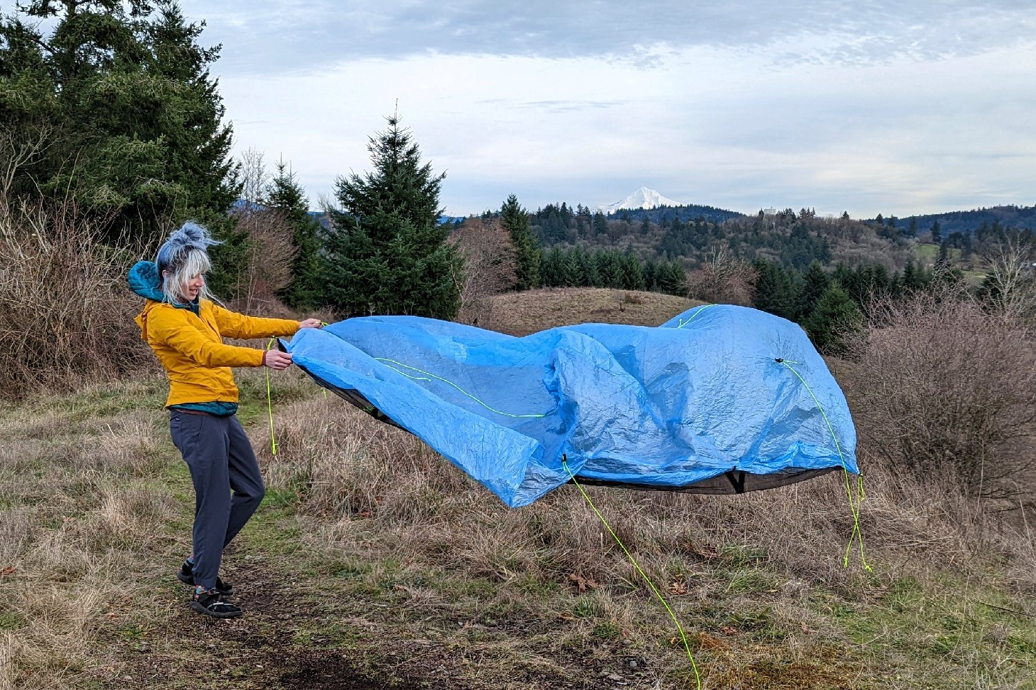 A hiker spreading out the Zpacks Plex Solo in a campsite