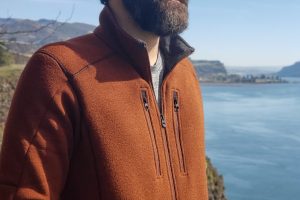 the upper body of a man wearing a KUHL interceptr rusty orange zippered fleece while overlooking the columbia river gorge