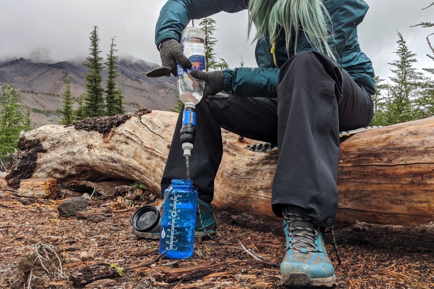 https://www.cleverhiker.com/wp-content/uploads/2023/08/A-backpacker-using-the-Sawyer-Squeeze-Water-Filter-to-filter-water-into-a-Nalgene-water-bottle.jpeg