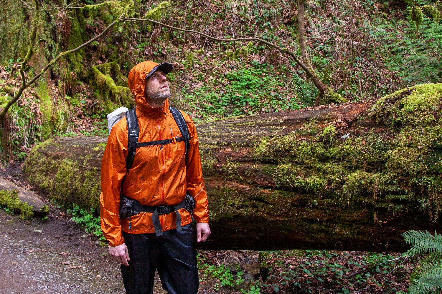 A backpacker wearing the Outdoor Research Helium Rain Jacket