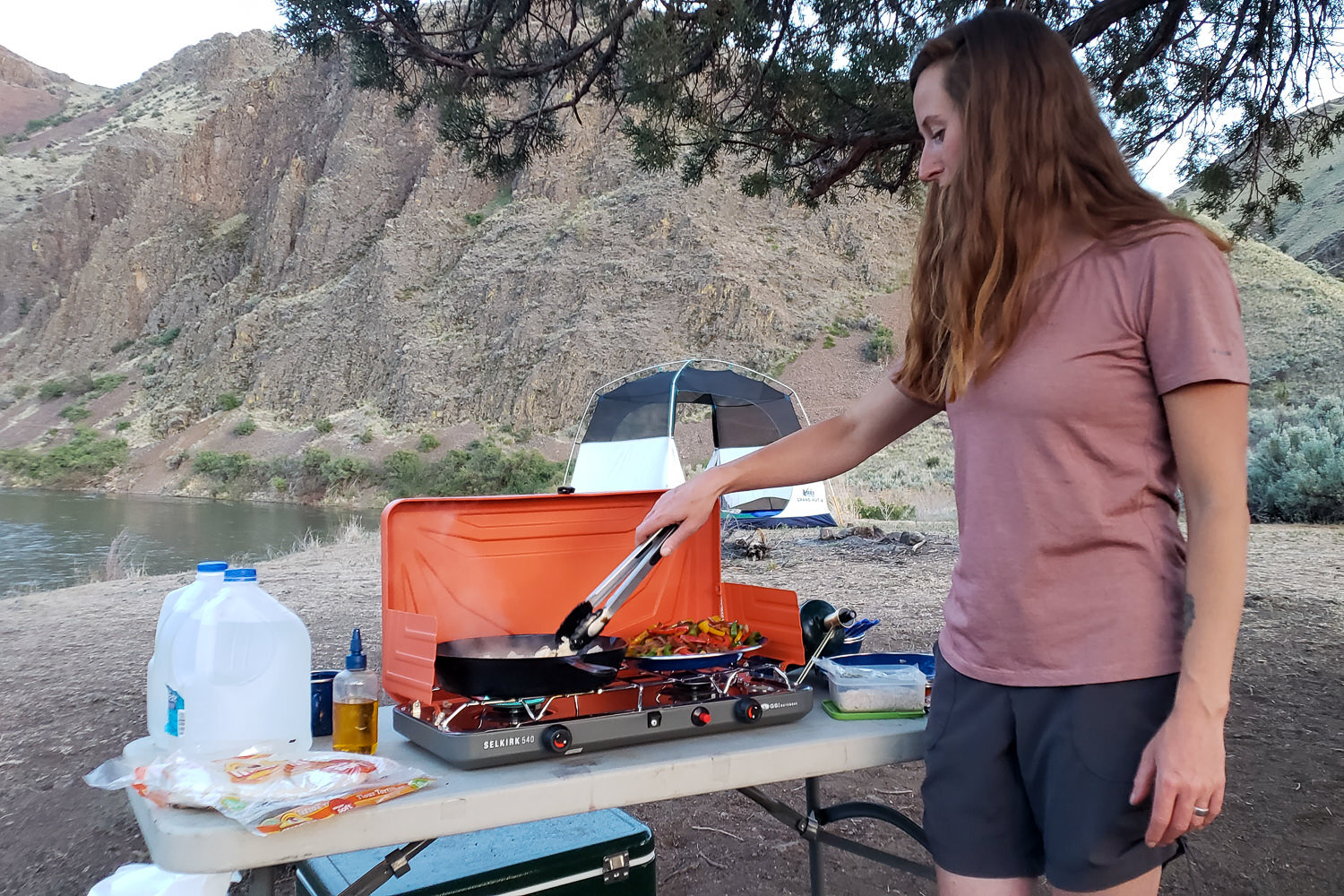 https://www.cleverhiker.com/wp-content/uploads/2023/08/A-camper-cooking-fajitas-on-the-GSI-Outdoors-Selkirk-540-Stove.jpeg