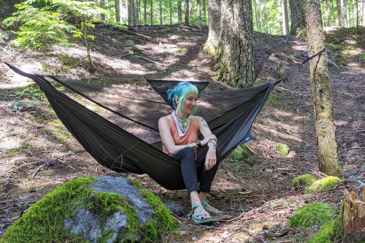 A hiker sitting in the Hennessy Ultralite Backpacker Hammock