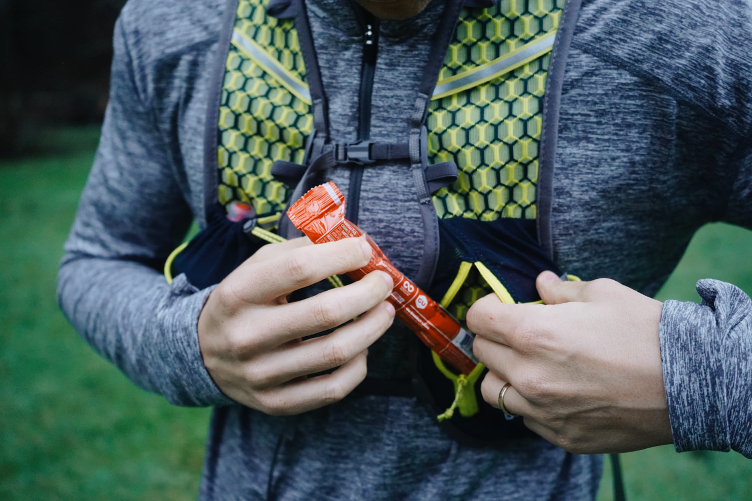 https://www.cleverhiker.com/wp-content/uploads/2023/08/Closeup-view-of-a-runner-taking-a-snack-out-of-the-pocket-of-their-running-vest.jpeg