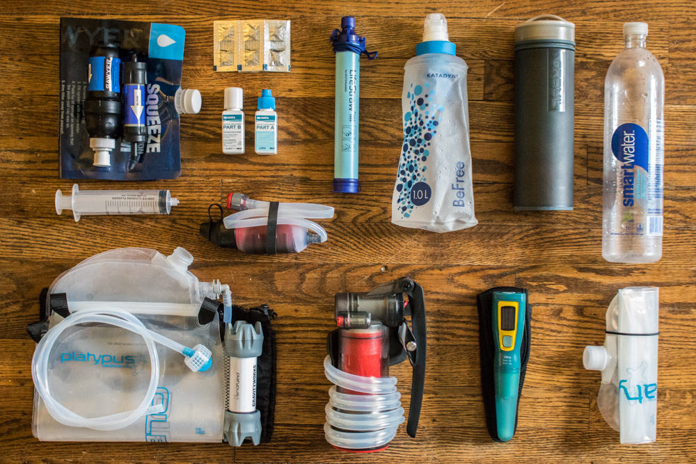 https://www.cleverhiker.com/wp-content/uploads/2023/08/Top-down-view-of-the-best-backpacking-water-filters-on-the-market-laid-out-on-a-table-for-size-comparison.jpeg