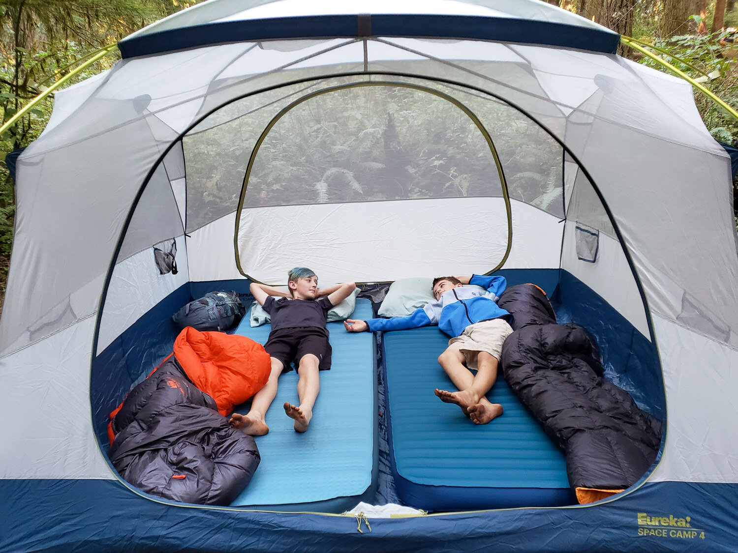 https://www.cleverhiker.com/wp-content/uploads/2023/08/Two-kids-relaxing-in-a-tent-on-the-NEMO-Roamer-and-Therm-a-Rest-MondoKing-3D-Camping-Mattresses.jpeg
