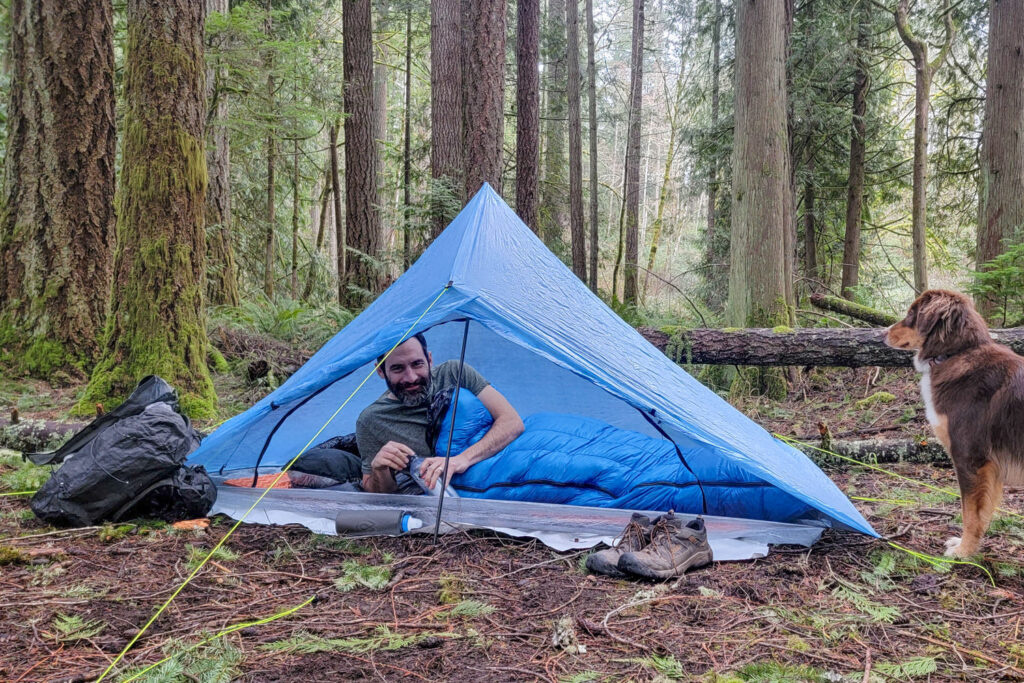 A backpacker sitting up in the Zpacks Plex Solo tent in the Zpacks Mummy Bag