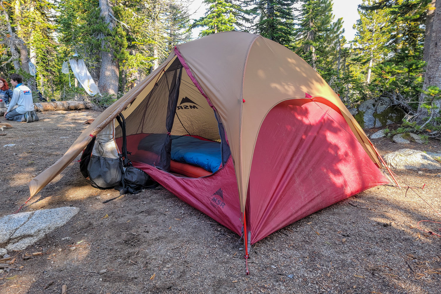 a tent set up in camp with the door and vestibule door unrolled.