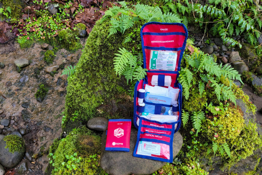 The HART Extended First Aid Kit on a rock with moss and ferns