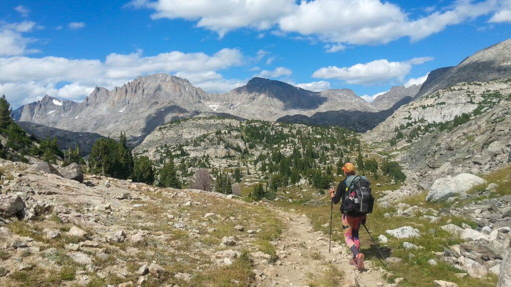 Thru-hiker backpacking on the Continental Divide Trail in the sunny alpine.