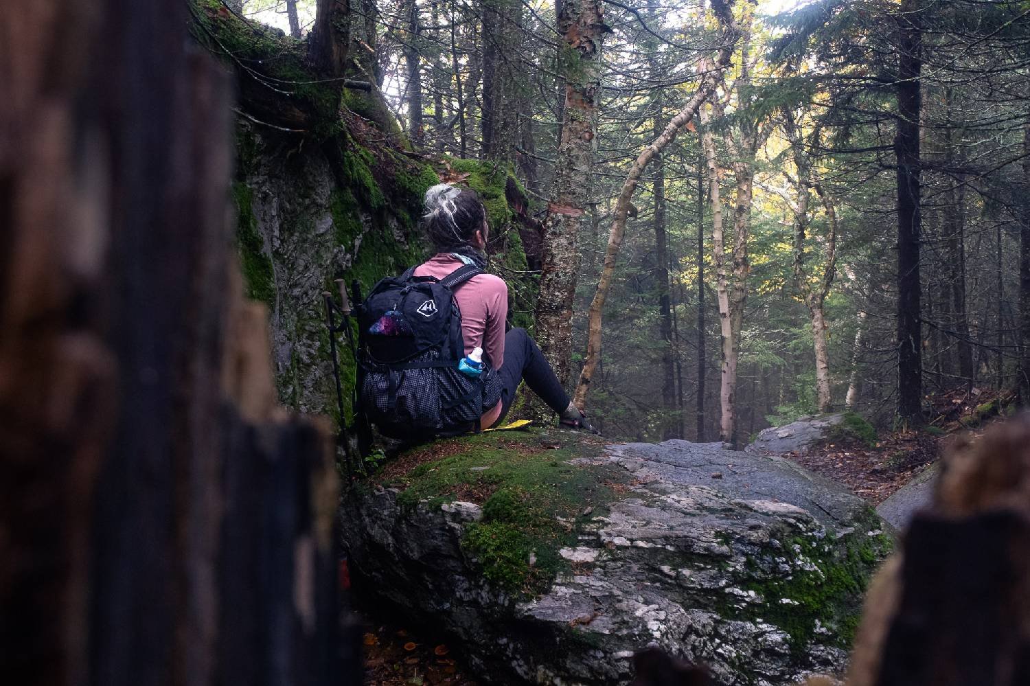 Thru-hiker on the Appalachian Trail sits down on rock in the forest