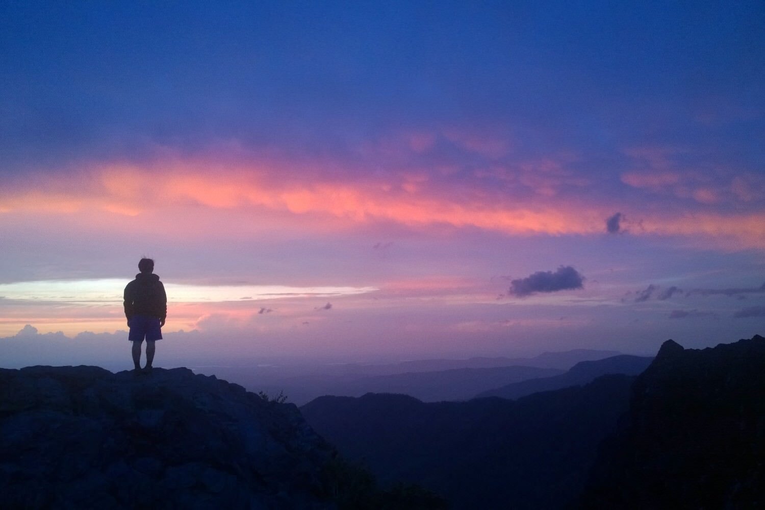 thru-hiker silhouetted by a blue and pink sunset on the Appalachian Trail.