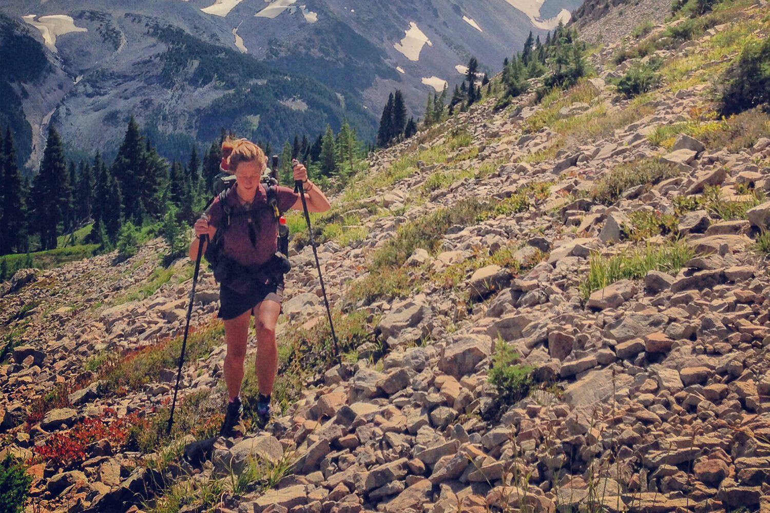 Thru-hiker walking uphill with trekking poles