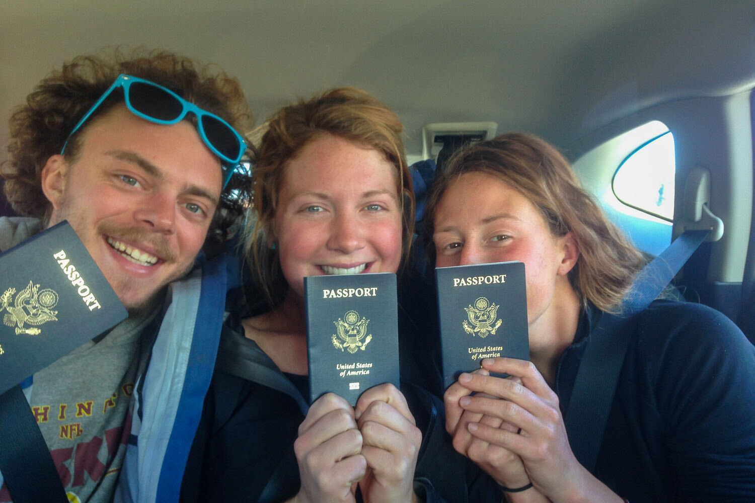 three thru-hikers holding up their USA passports