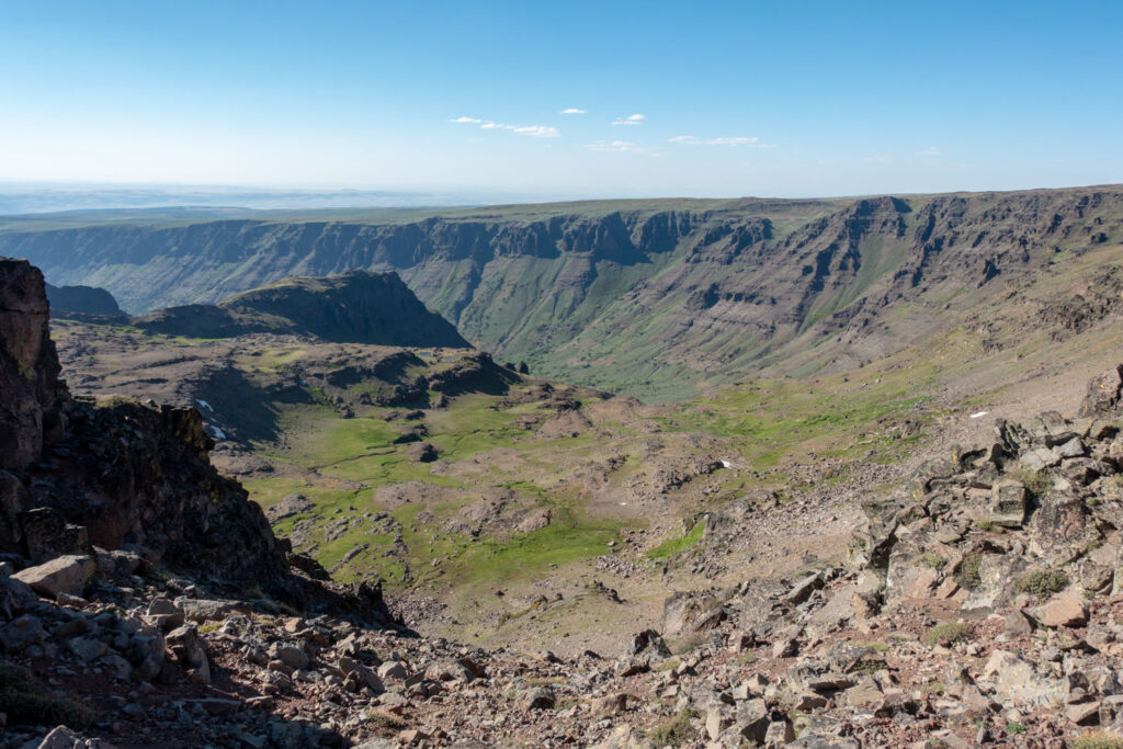 a view of the steens from the top showing steep red and green canyon walls 