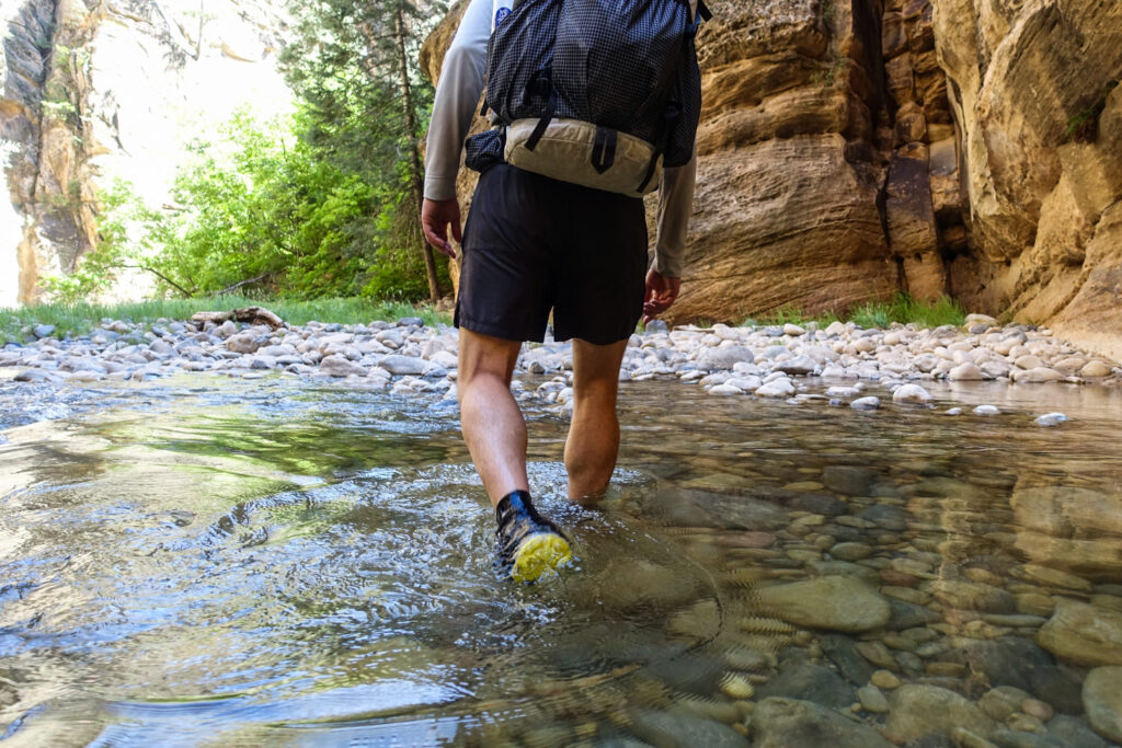 a hiker walking through the virgin river on the narrows 16 mile hike