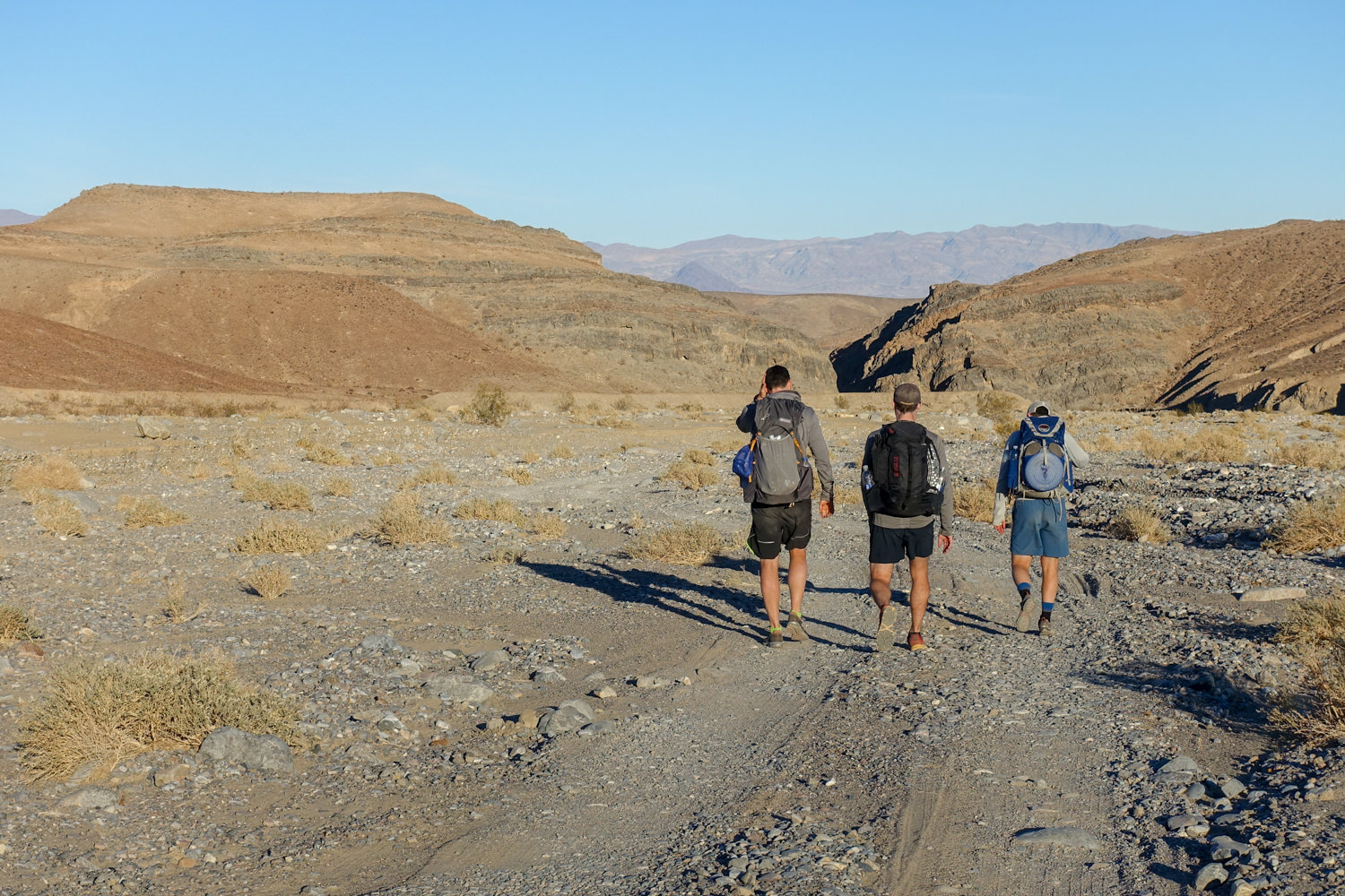 backpackers on a dirt two-track heading out of the cottonwood marble canyon loop