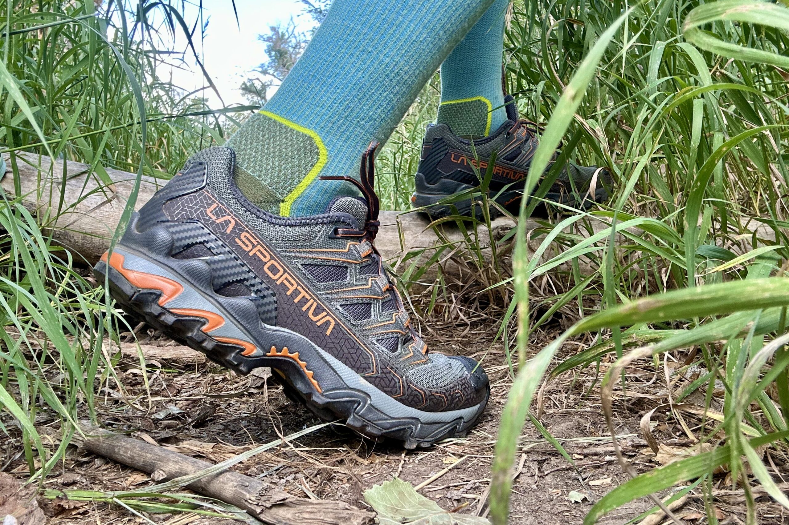 Close up of a hiker walking in a forested setting from the knees down.