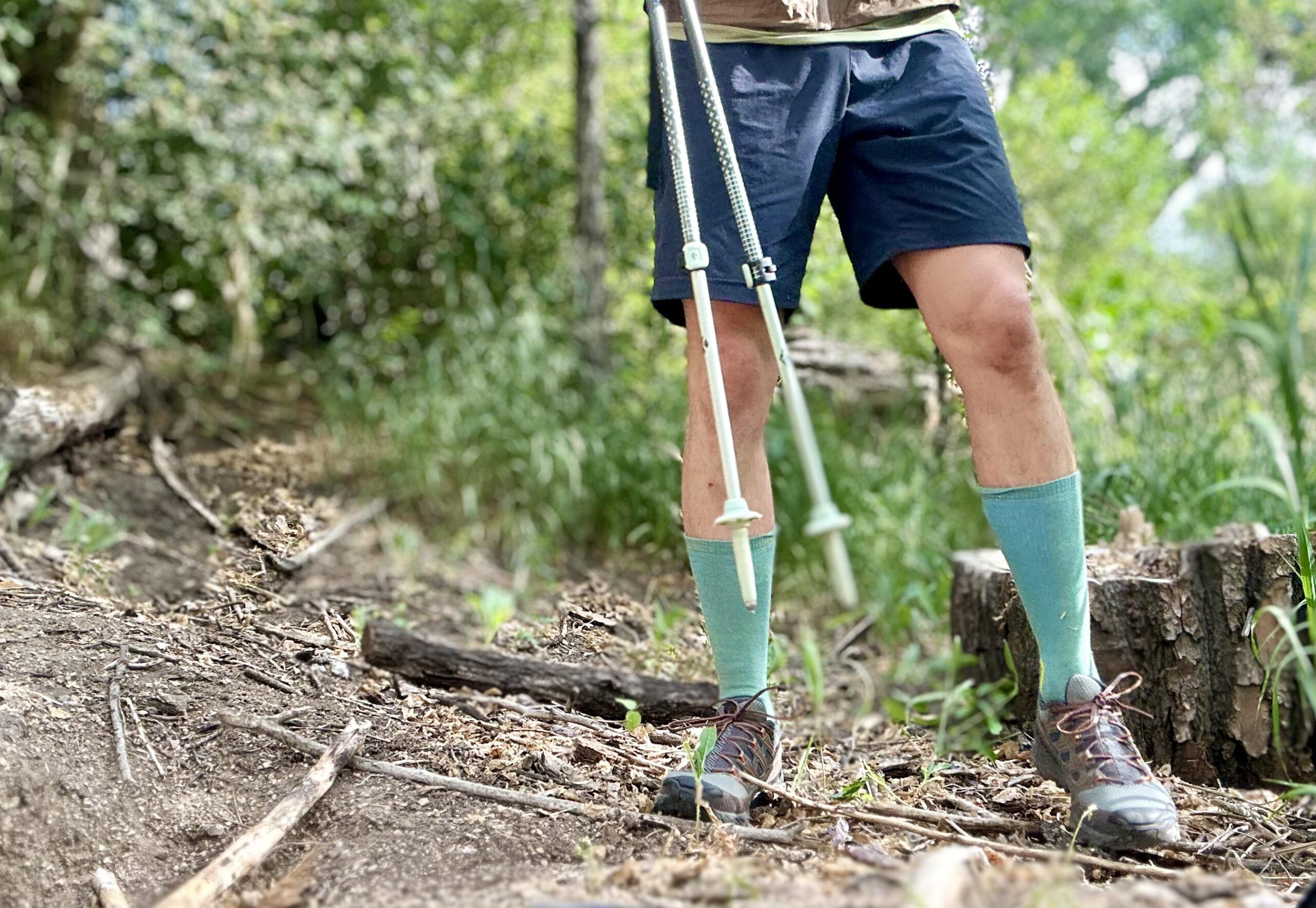 A hiker from the waist down poses in a forest setting