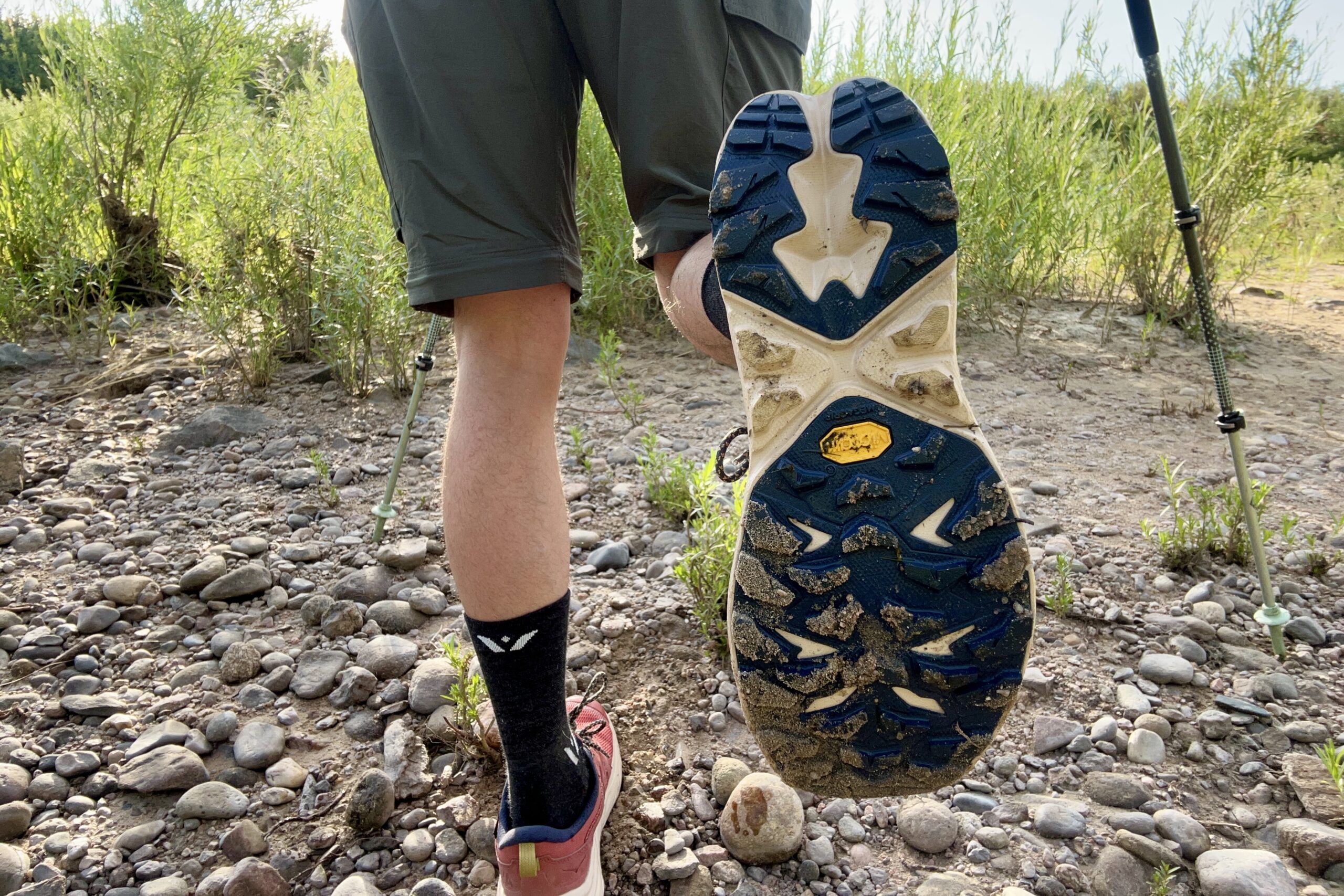 A male hiker shows off the tread of his hiking shoe.