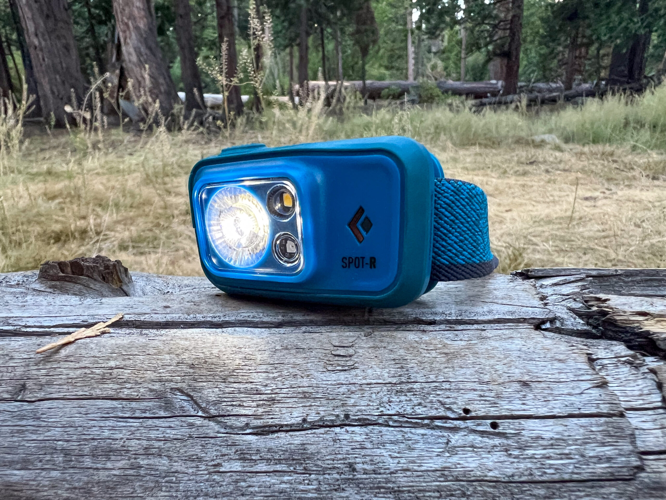 The image shows a Black Diamond Sport 400 - R headlamp sitting on a log.