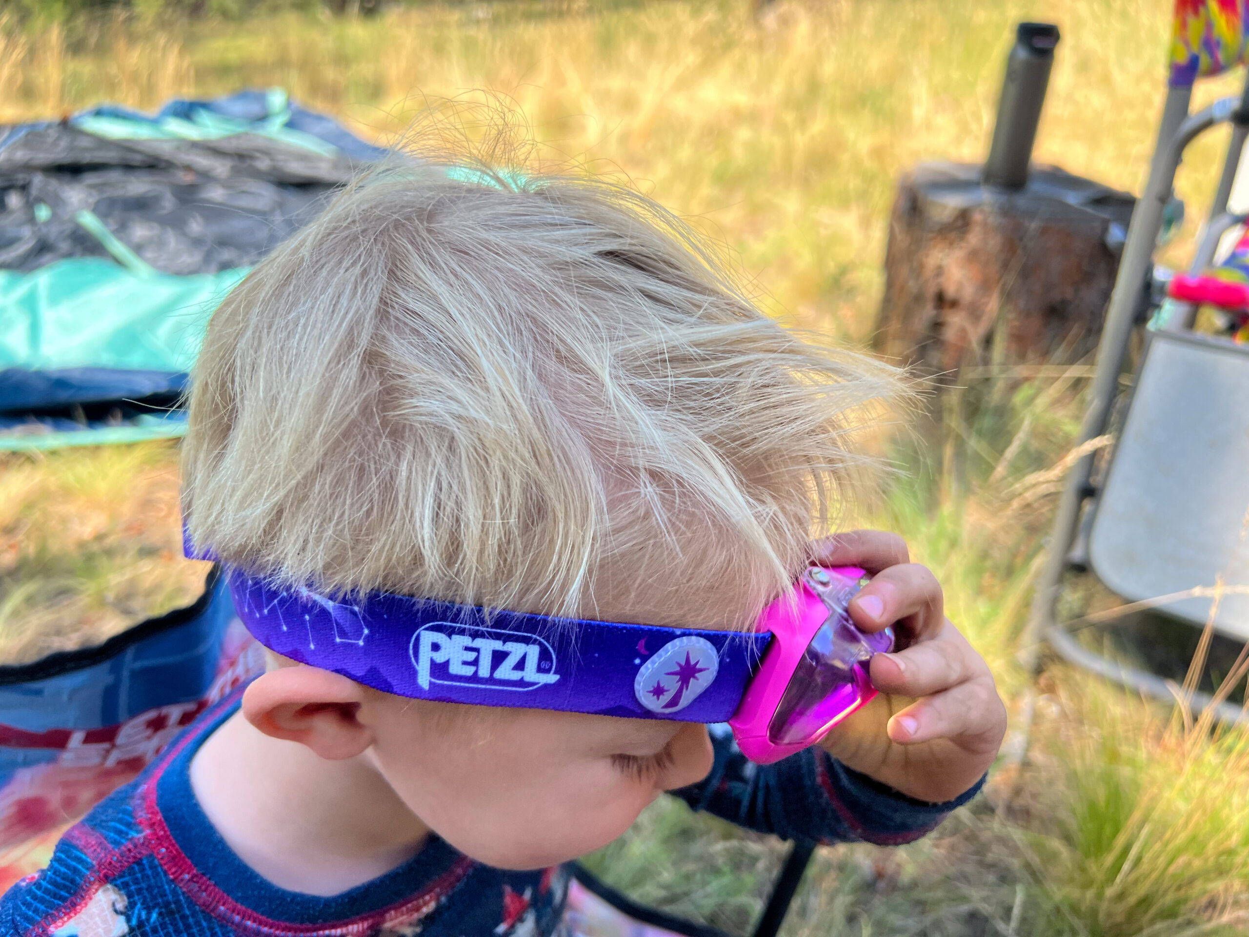 The image shows a child adjusting their headlamp.