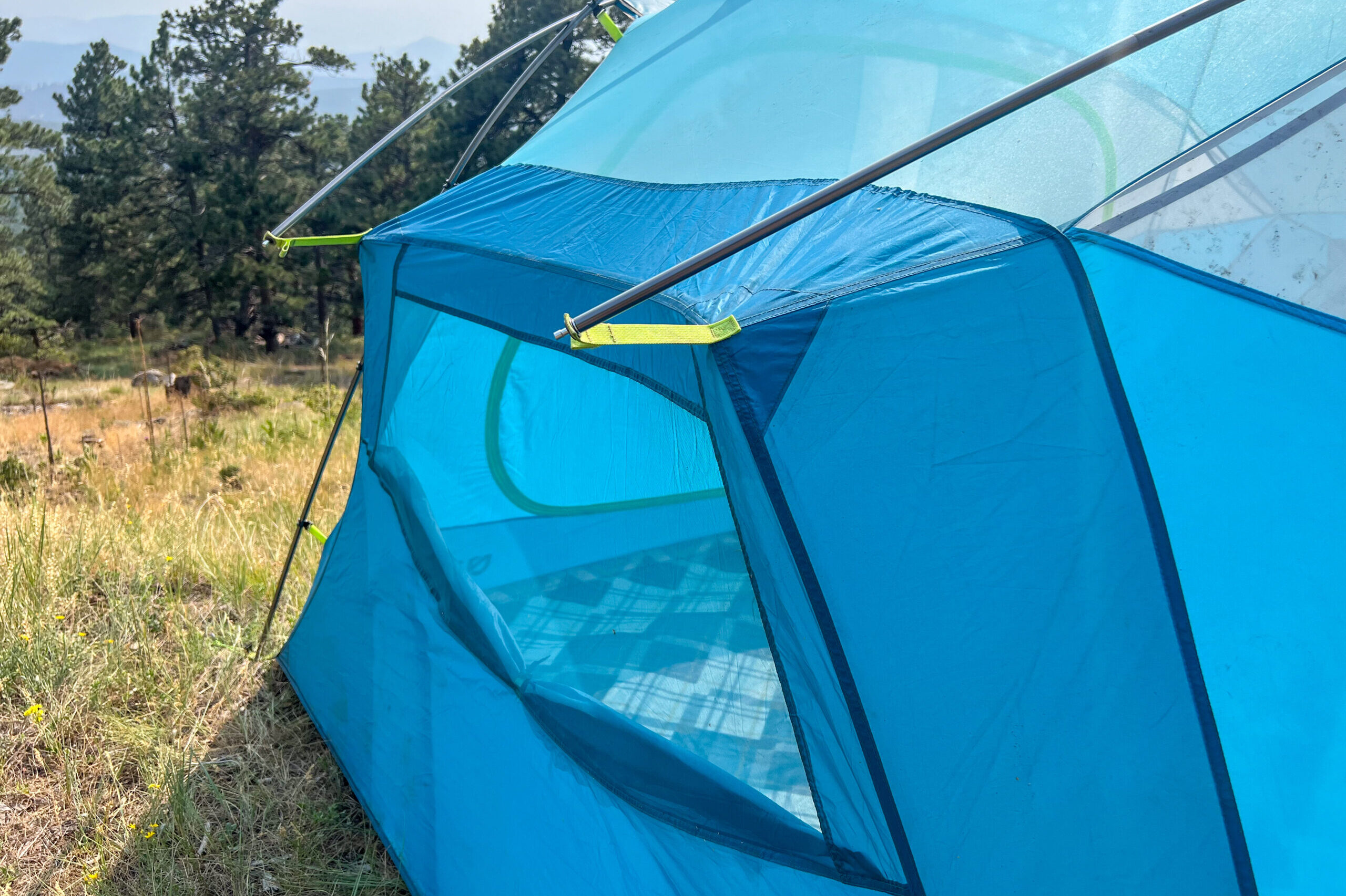 The image shows a side view of the Nemo Aurora Highrise Tent with two of the securely fastened inside their corresponding grommets.