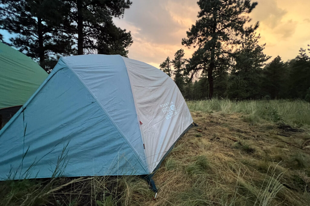 The image shows a side shot of the Mineral King 3 in a grassy environment set against a burnt orange sky.