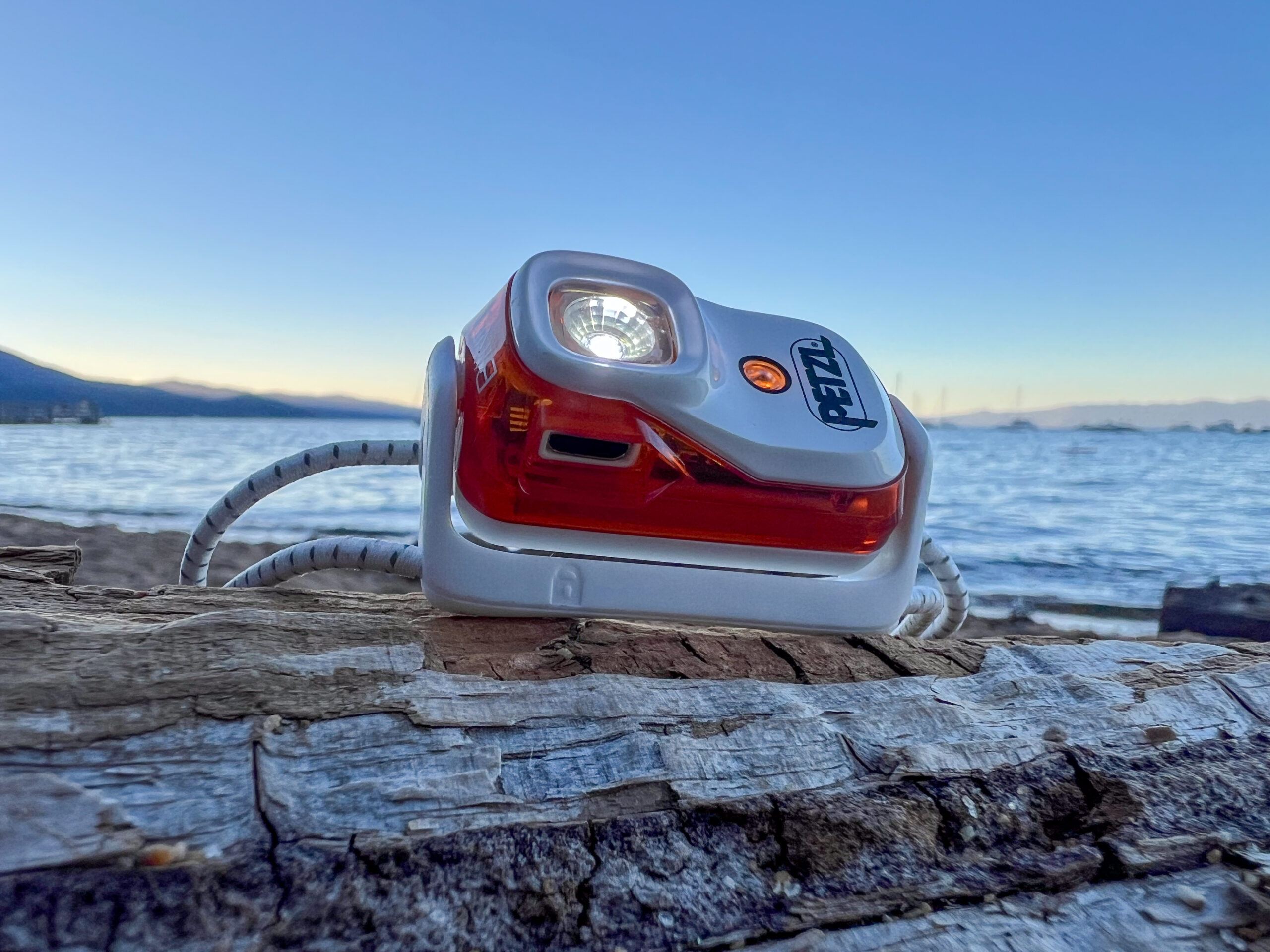 The image shows a Petzl Bindi headlamp battery indicator light. The light is orange indicating it will need to be charged soon.