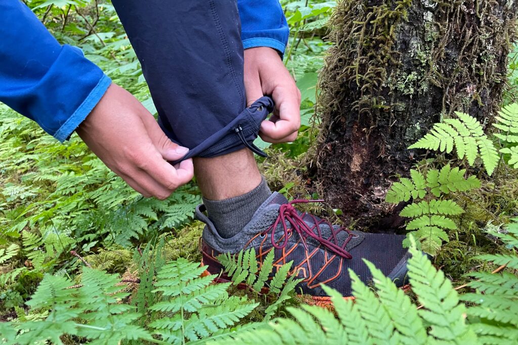 A man cinches the cuffs of his pants.