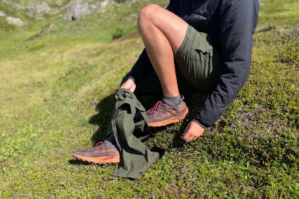 A man removes the lower portion of his convertible cargo pants.