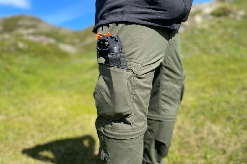 A closeup of bear spray carried in cargo pockets