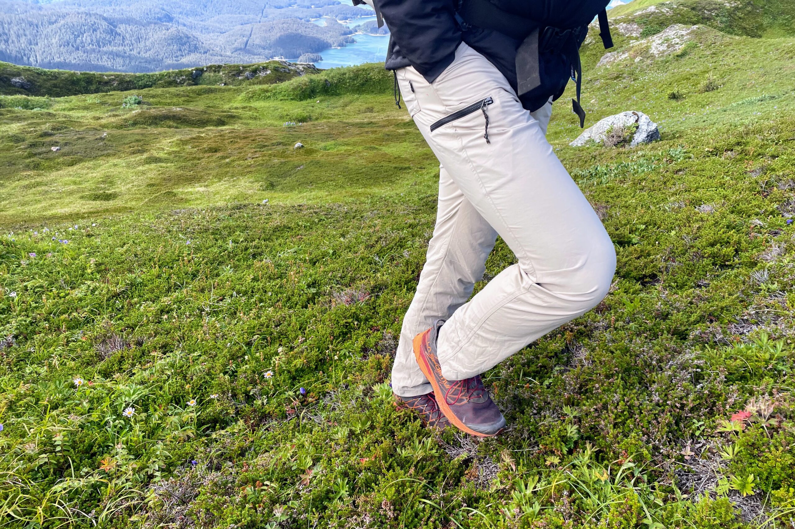 A closeup of walking uphill with tan pants through the tundra