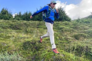 A man runs downhill in the tundra.