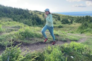 A man runs uphill with an alpine background.