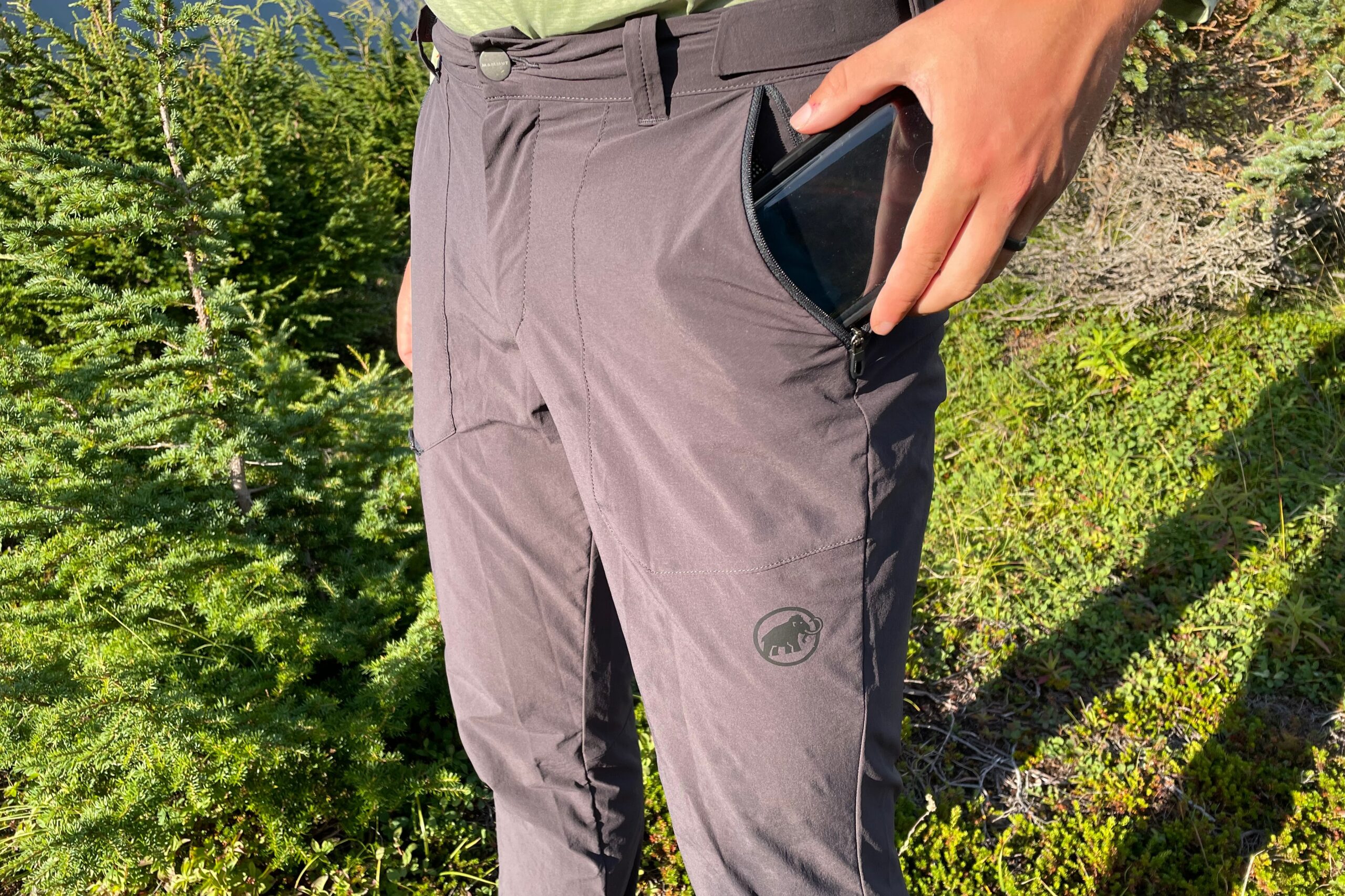 A man puts a phone in pants pocket.