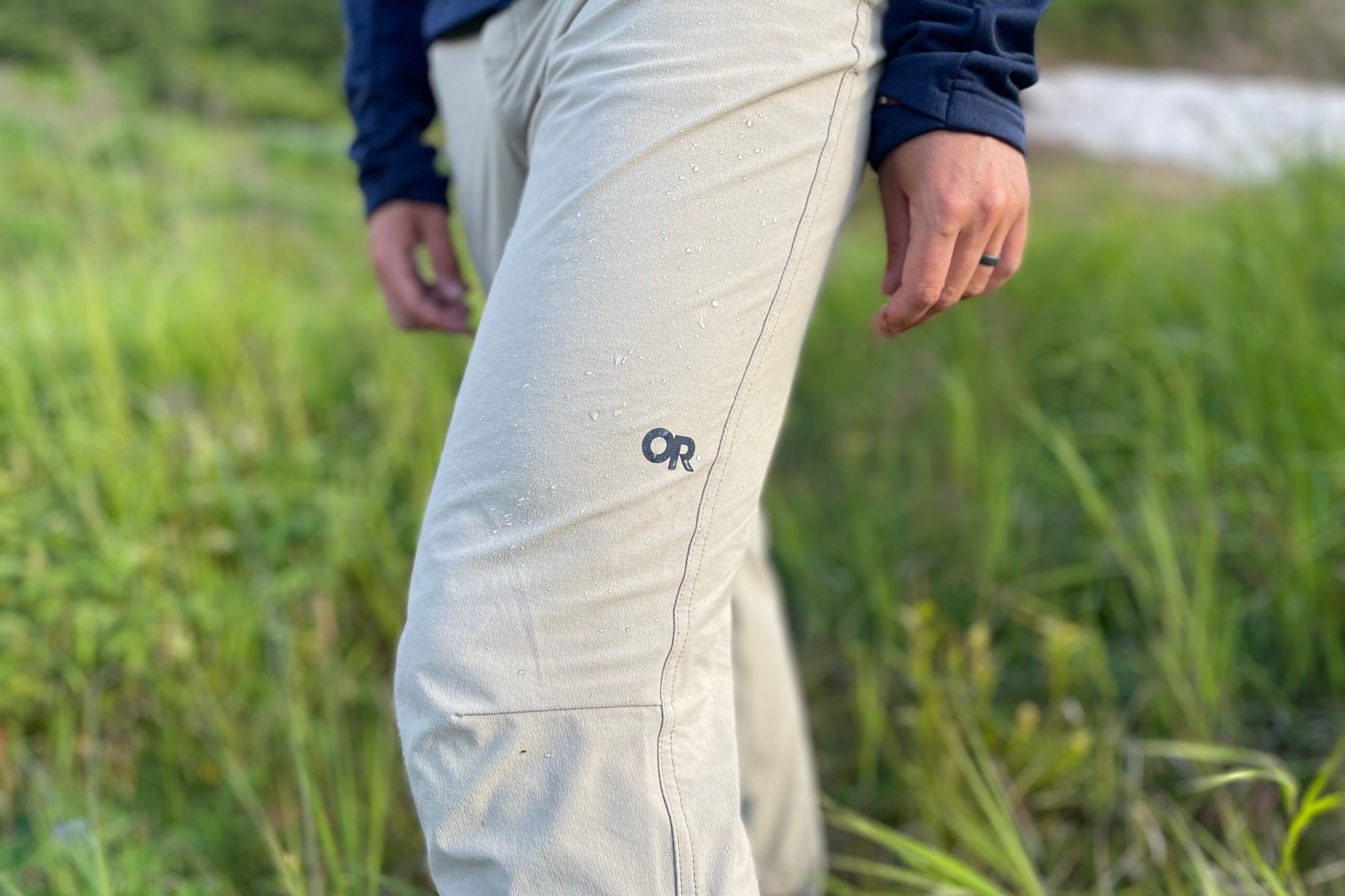 A closeup of the logo of a pair of pants with water droplets.