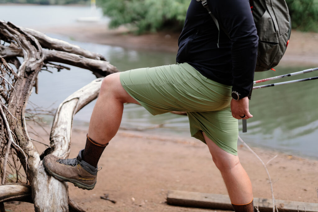 A leg on a log stretching a pais of shorts.