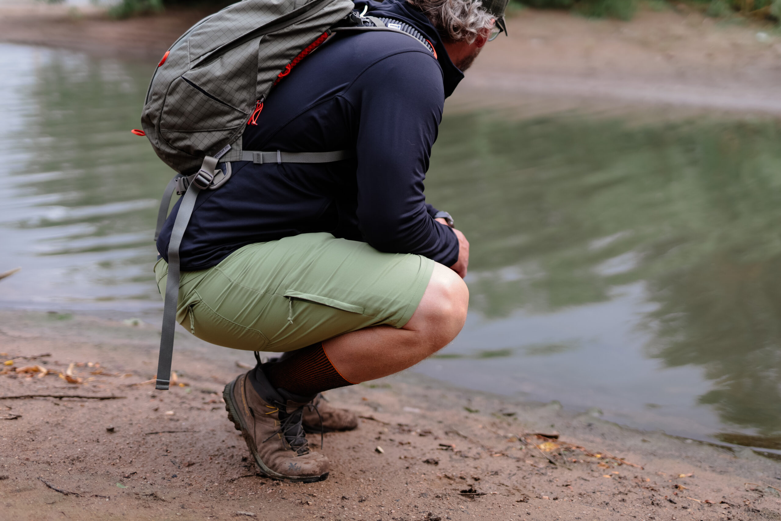 A man kneeling by a stream.