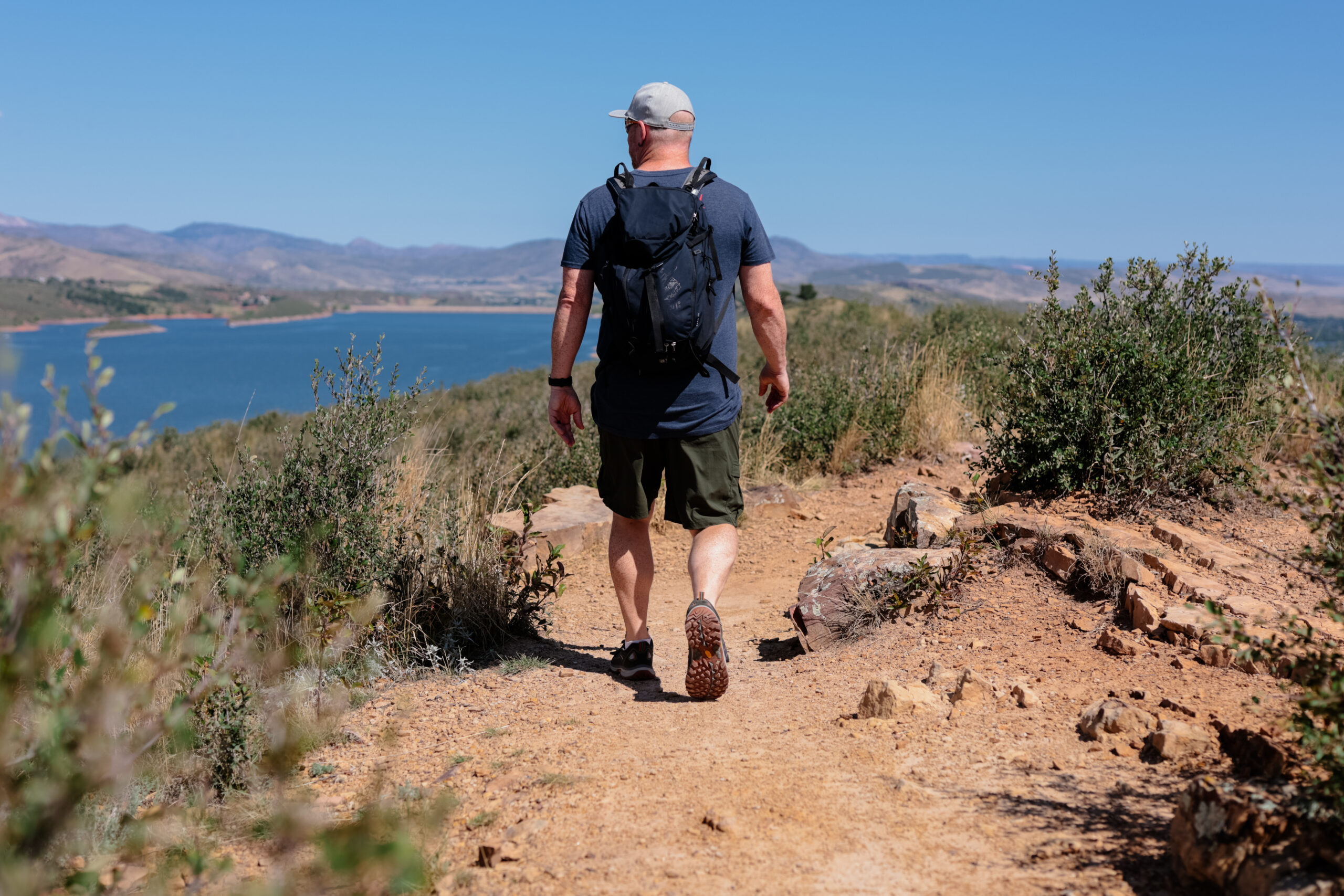 Man walking along trail in shorts.