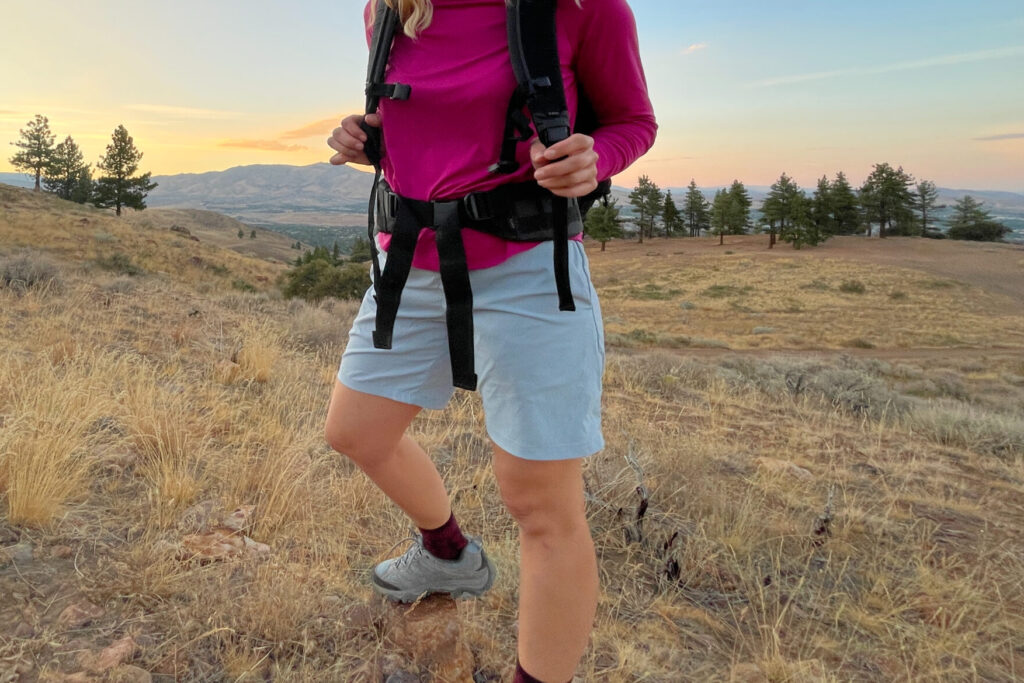 A gear analyst wearing lightweight blue houdini wadi shorts at sunset on a clear evening