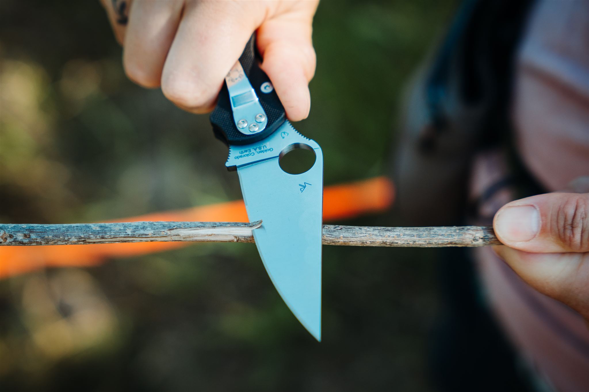 Using the Spyderco Para Military 2 pocket knife to trim bark off of a thin stick