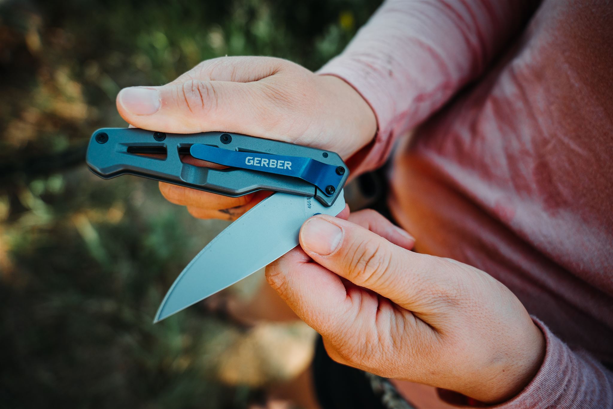 The Gerber Paralite pocket knife being opened with an outdoor background