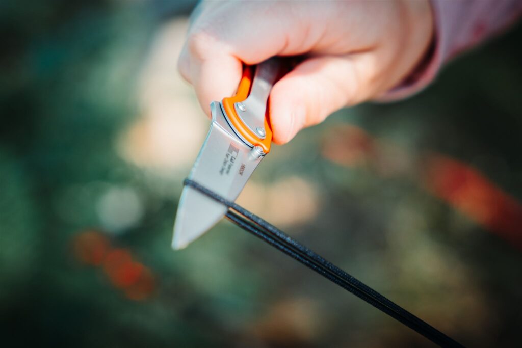 Using the Kershaw Leek pocket knife to cut a piece of paracord