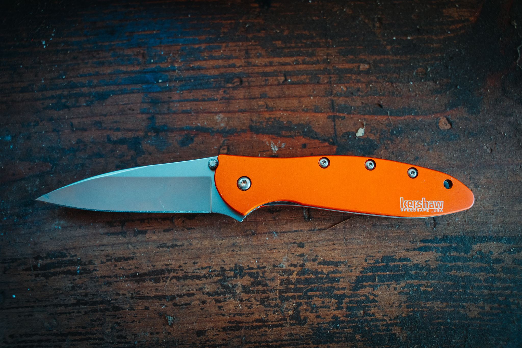 Product photo of an open Kershaw Leek pocket knife on wooden background