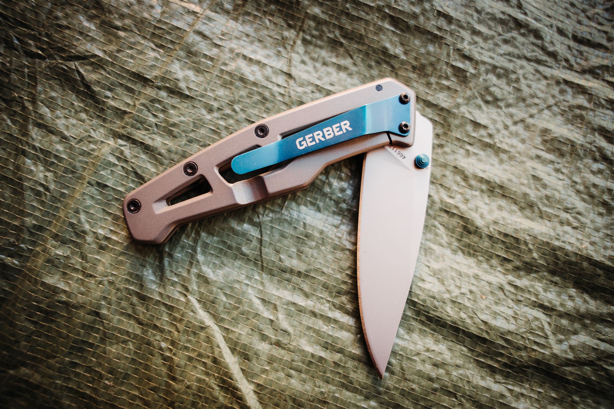 Product photo of partially opened Gerber Paralite pocket knife on green background