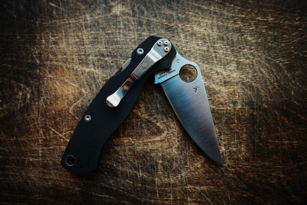 Product photo of the Spyderco Para Military 2 on a wooden background partially opened