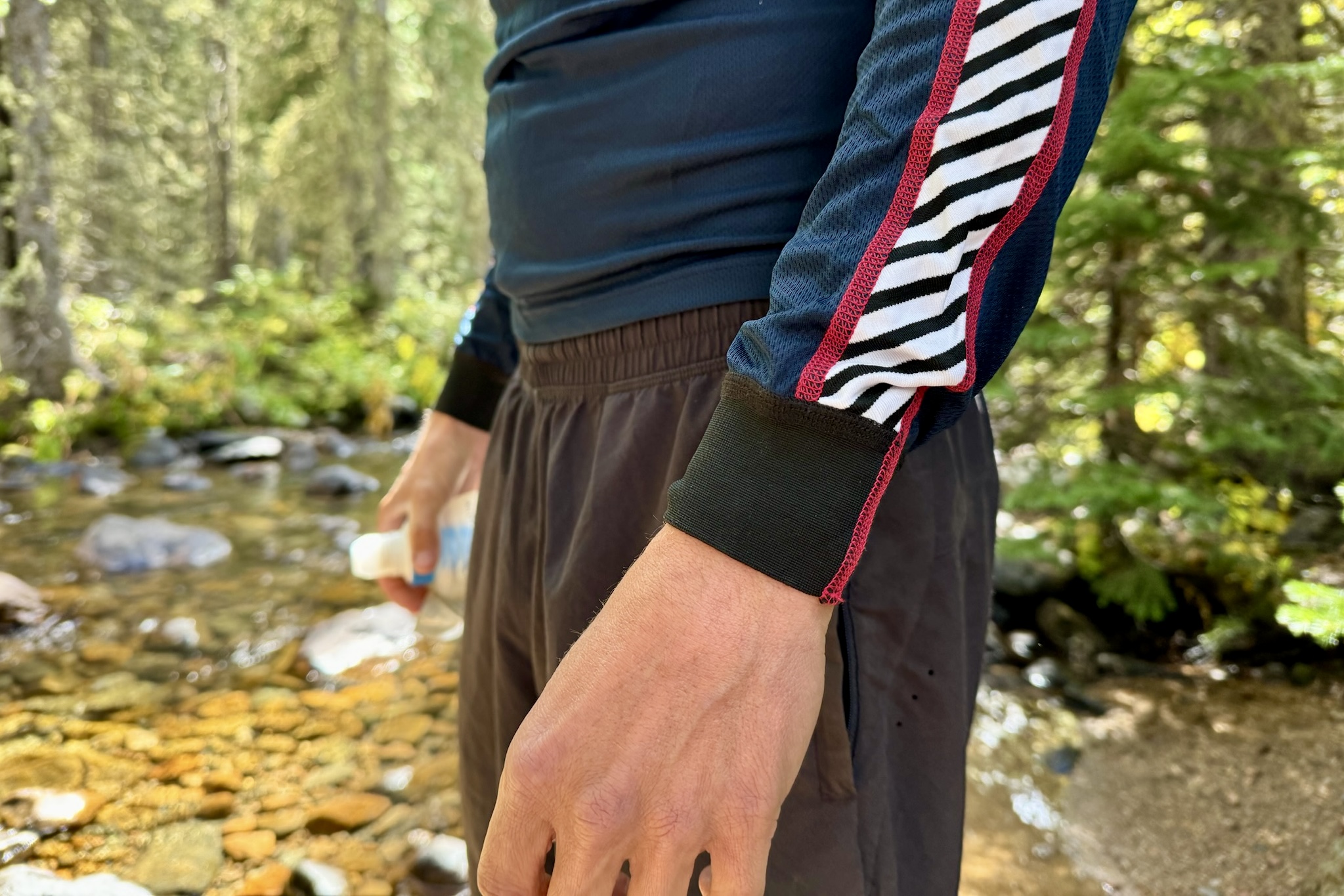 A close up of the wristbands on the Helly Hansen Lifa Stripe base layer. Trees and a creek are in the background.